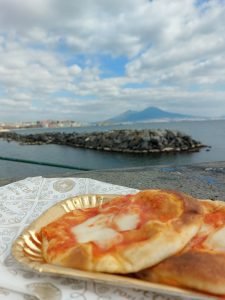 Foto dettaglio pizza con vista Vesuvio da scalini discesa Lungomare di Napoli